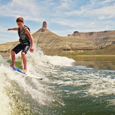 Boy with life jacket wakeboarding