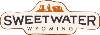Sweetwater Wyoming logo with brown rock formations above the words "Sweetwater Wyoming" on a beige, irregular-shaped background.